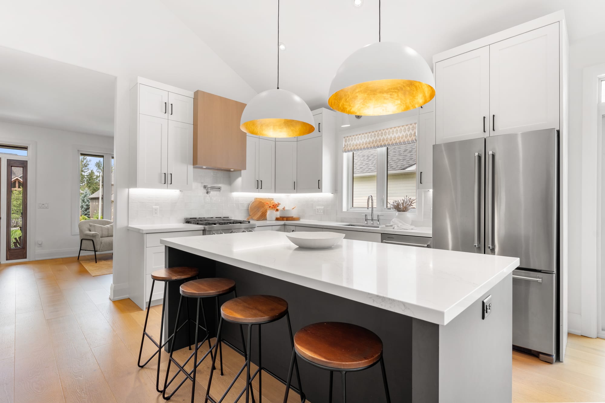Kitchen island seating four wood-topped stools, with panelled refrigerator and vaulted ceiling at 110 Mary Street, Collingwood