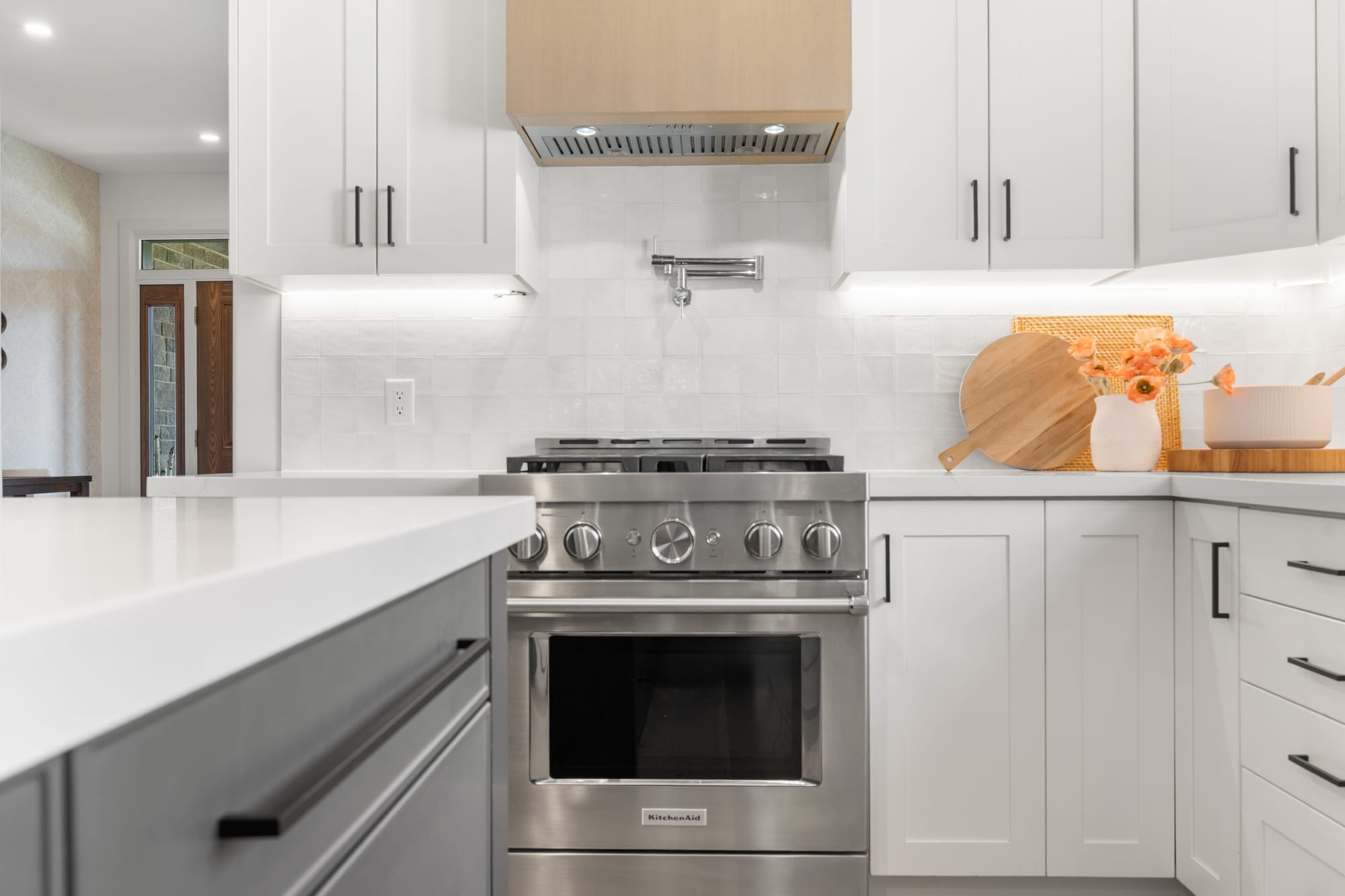 Detail of the gas range, pot filler and white oak range hood in the chef's kitchen at 110 Mary Street, Collingwood