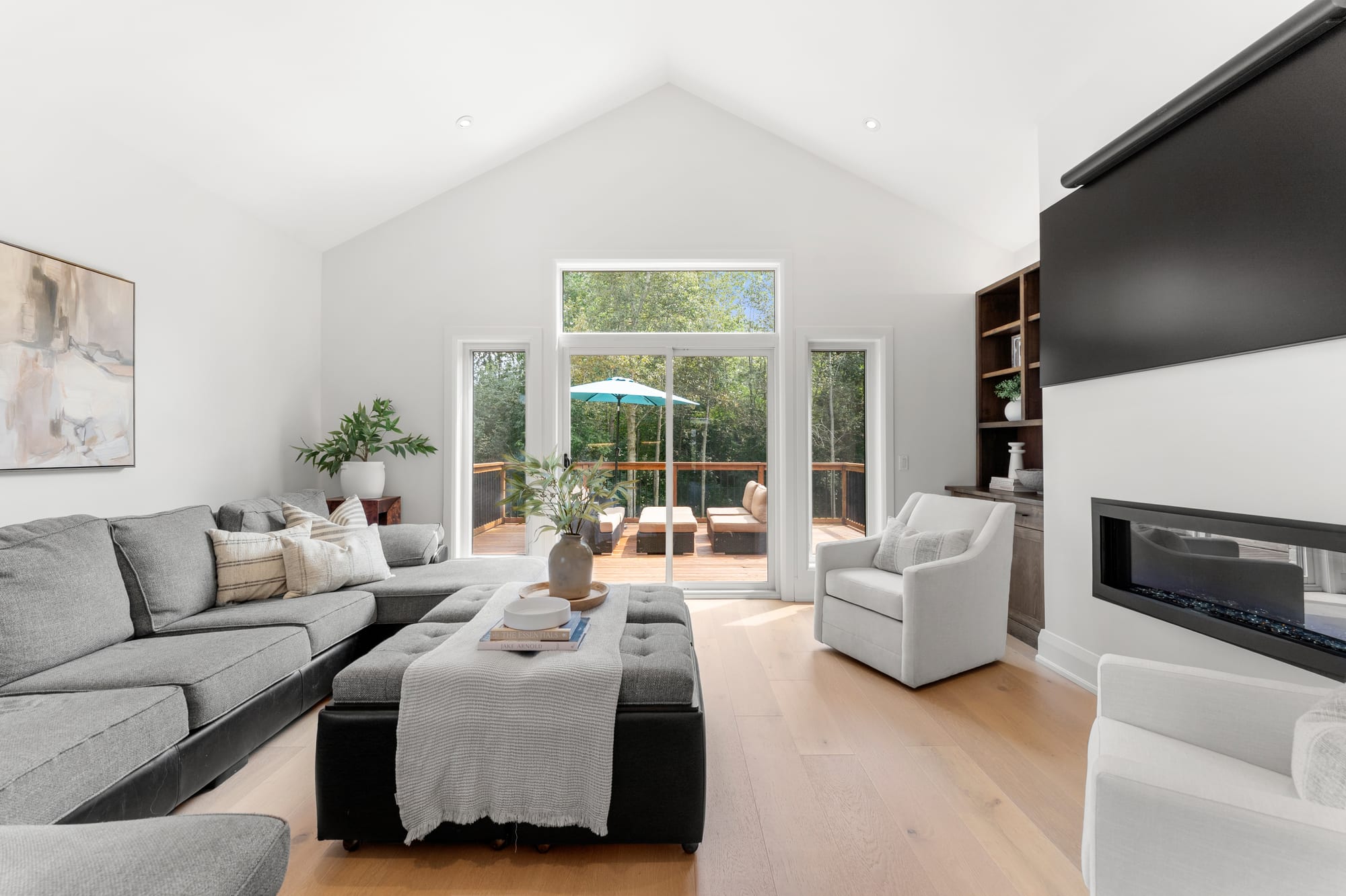 Vaulted great room at 110 Mary Street, Collingwood, with a linear gas fireplace and sliding doors opening onto the south-facing deck