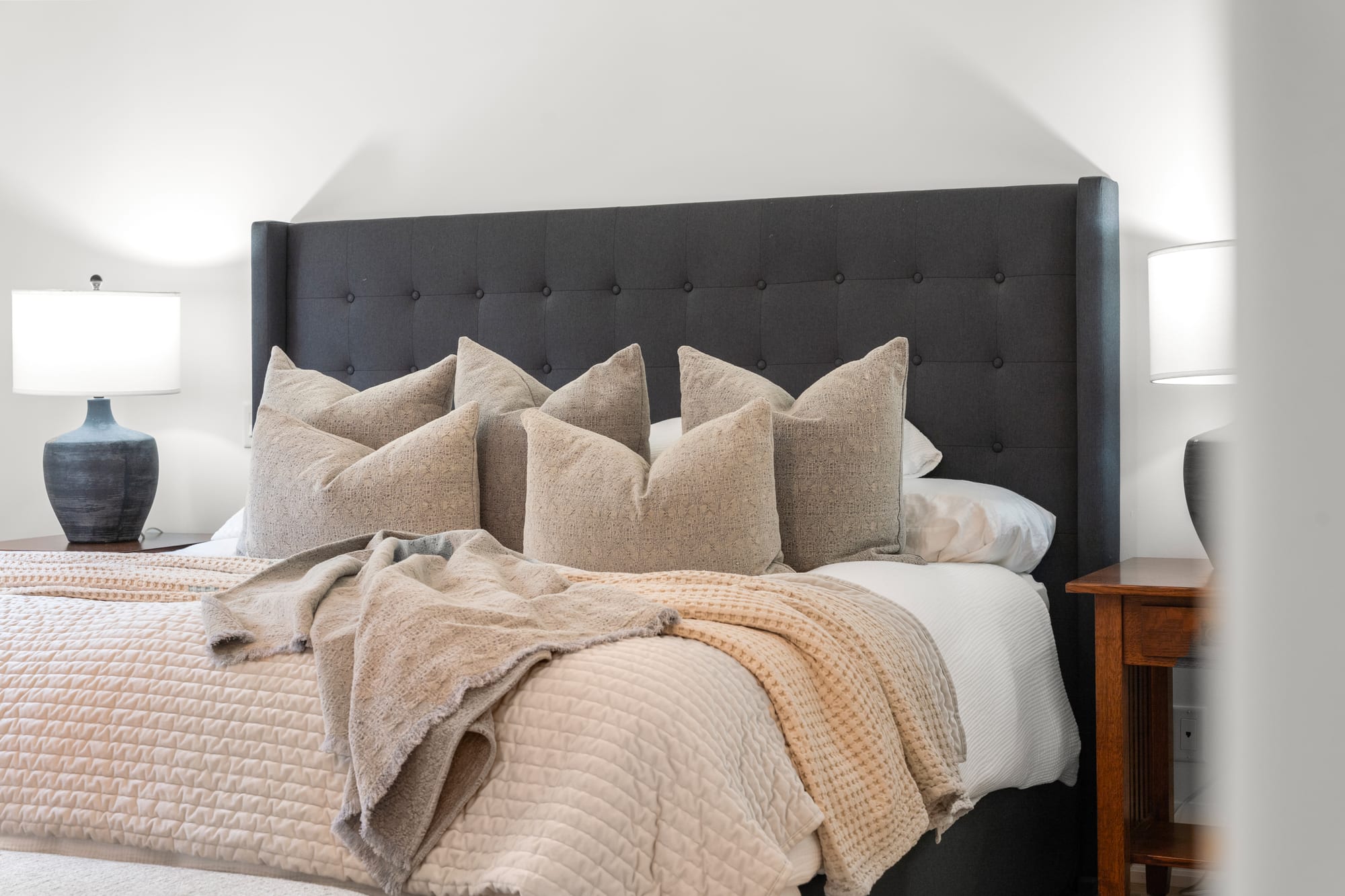 Layered bedding and matching bedside lamps against the tufted headboard in the primary suite at 110 Mary Street, Collingwood