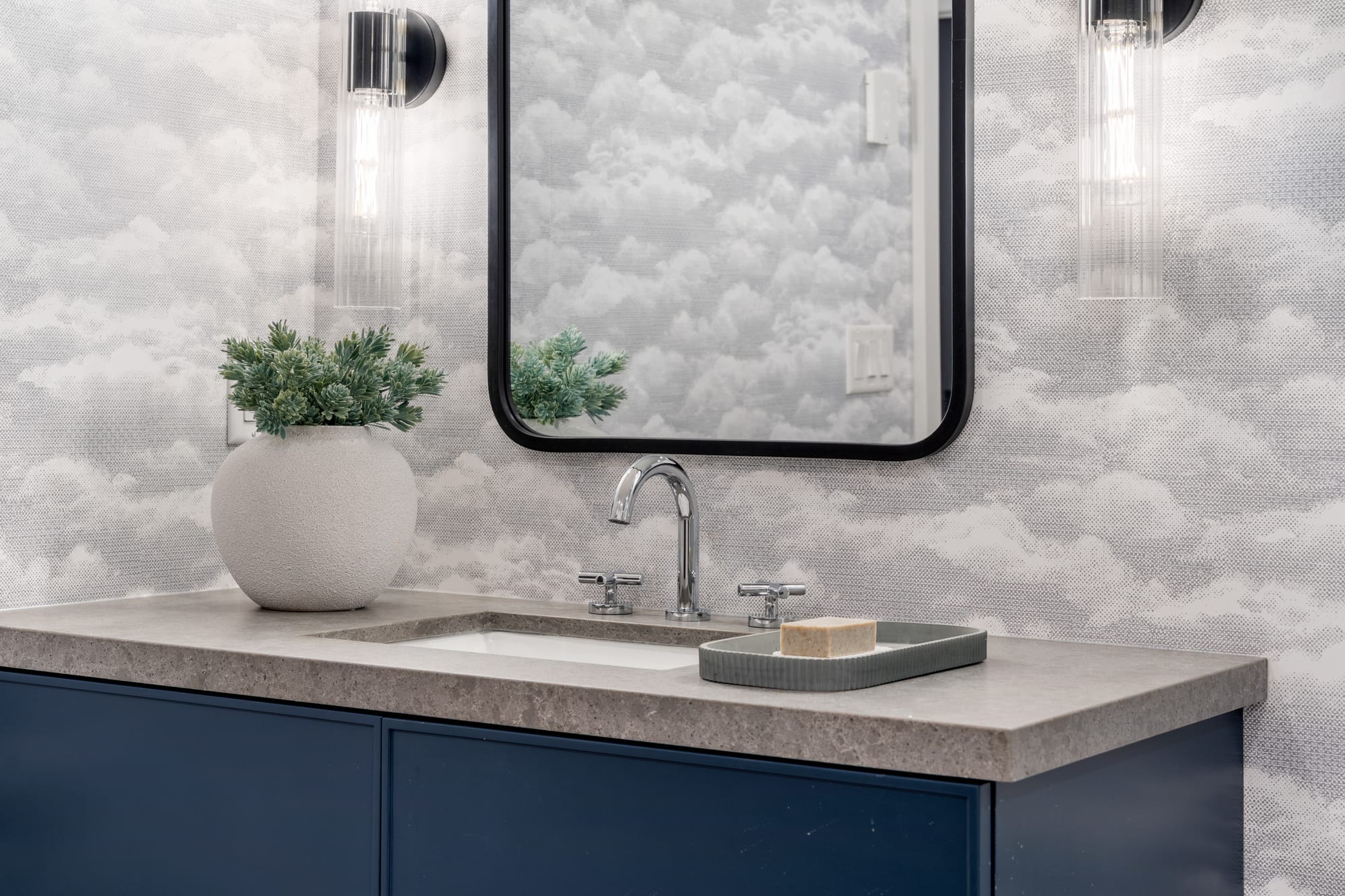 Navy vanity and stone counter against cloud-print wallpaper in the lower-level bathroom at 110 Mary Street, Collingwood