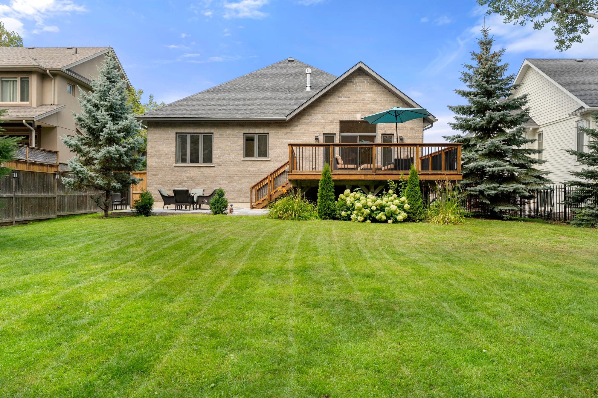 Wide view across the rear lawn to the back of the house and its elevated deck on the 65x165ft lot