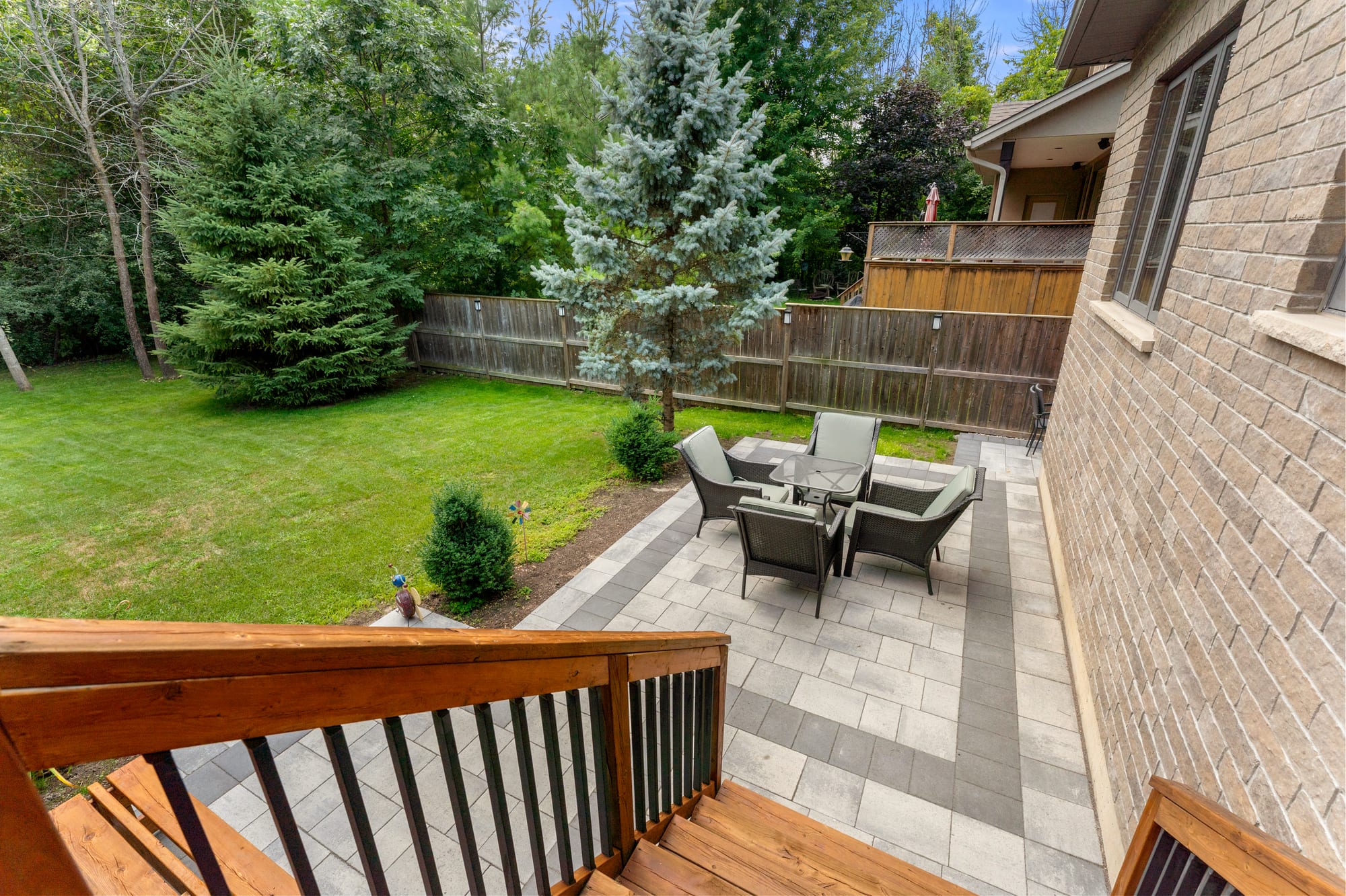 View from the deck stairs down to the paver patio and treed backyard at 110 Mary Street, Collingwood
