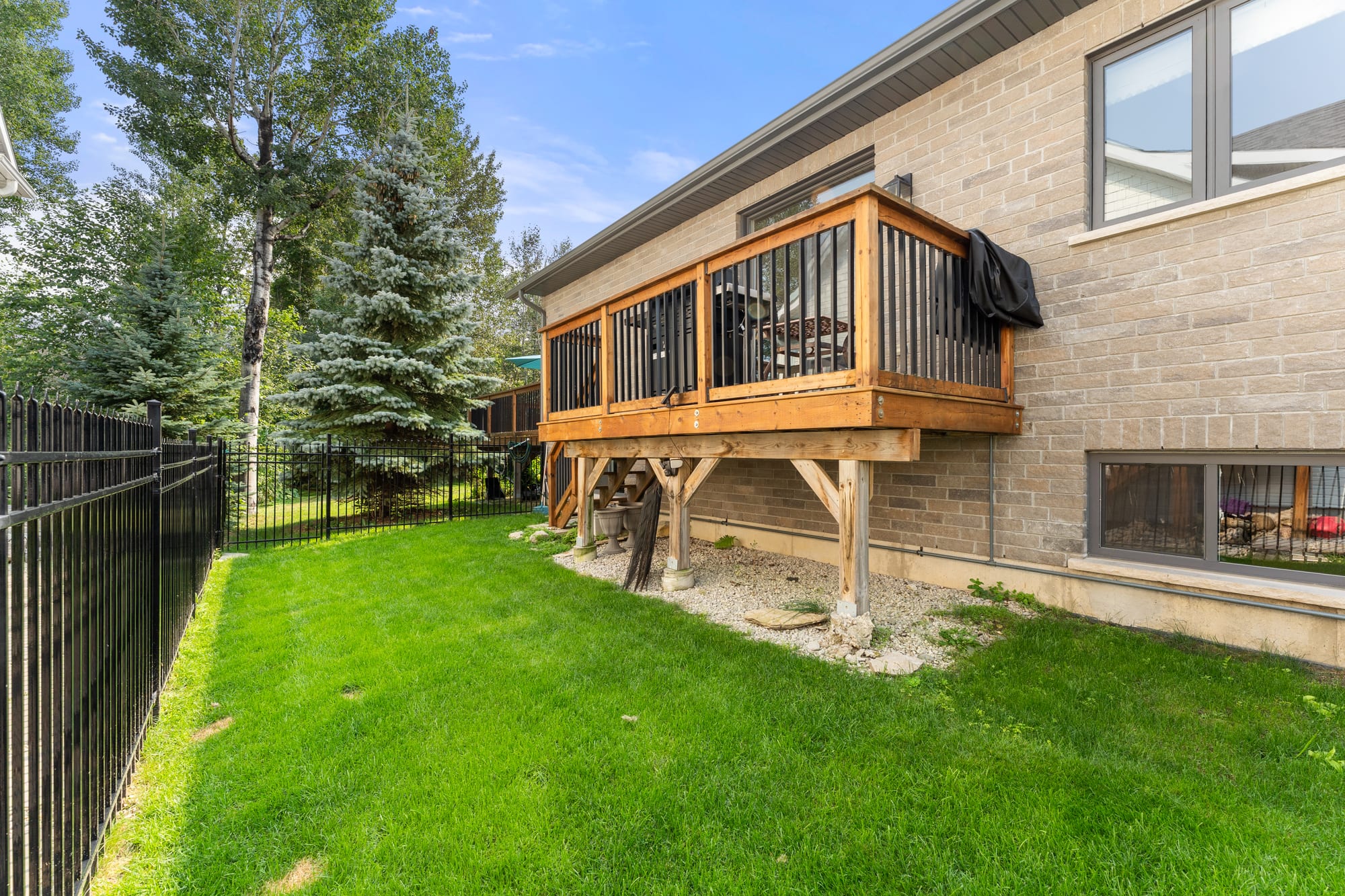 Side yard at 110 Mary Street, Collingwood, showing the raised deck, walk-out level and wrought iron fencing
