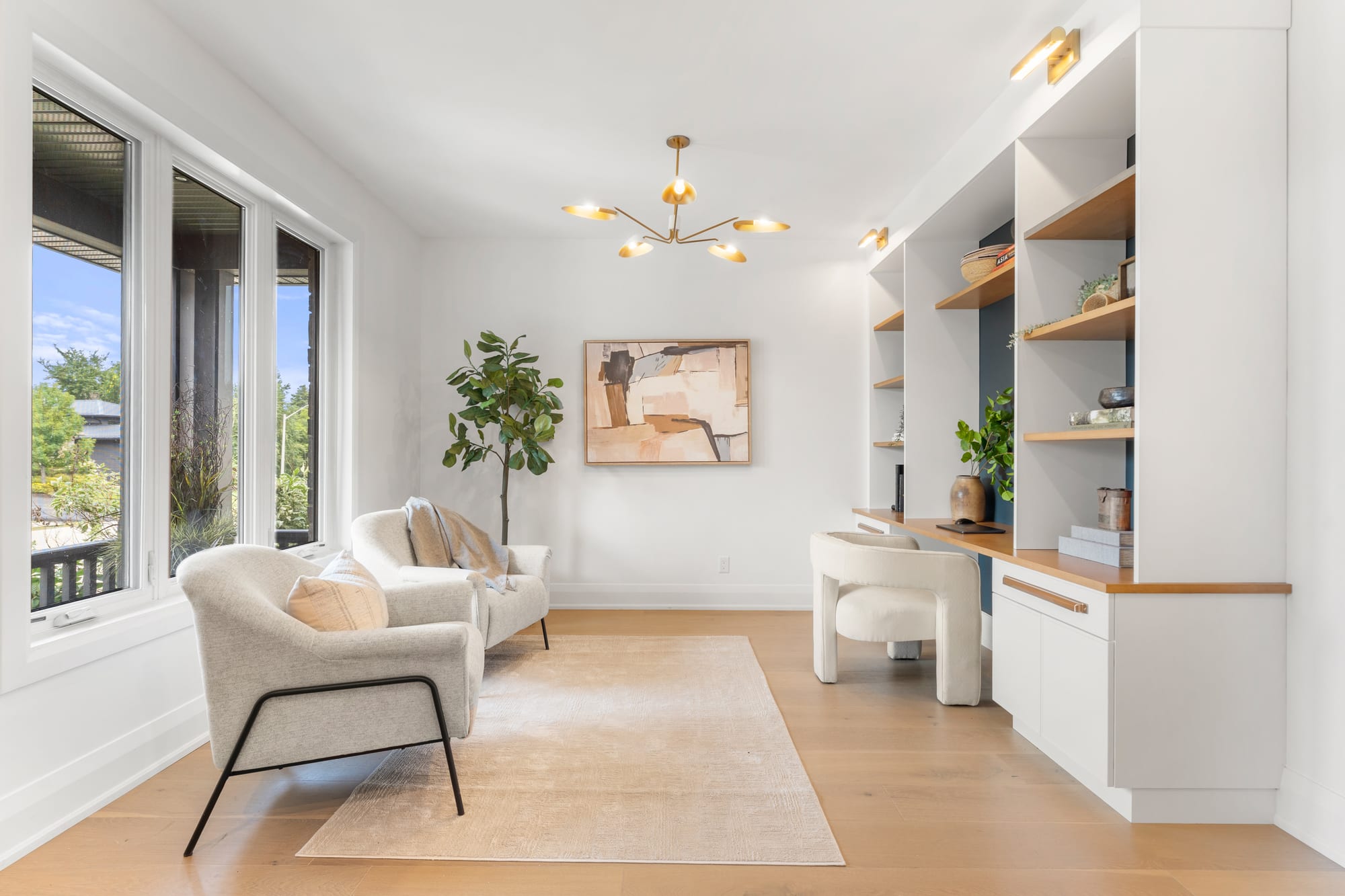 Front sitting room with two upholstered armchairs, a brass chandelier and a built-in desk nook at 110 Mary Street, Collingwood
